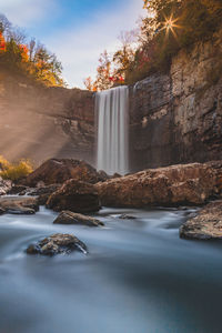 Scenic view of waterfall against sky