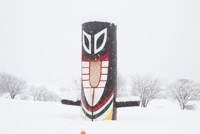 Text on snow covered field against sky