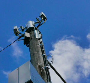 Low angle view of telephone pole against blue sky