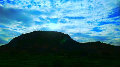 Scenic view of mountains against blue sky