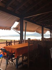 Chairs and tables in restaurant at beach against sky