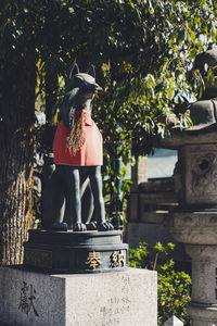 Statue against trees and plants