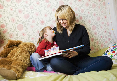 Mother reading book to her daughter