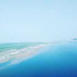 Scenic view of beach against clear blue sky