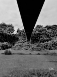 Close-up of below bridge over river against sky