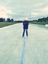 Full length rear view of man skateboarding