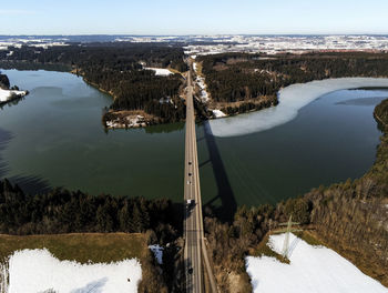 Drone shot over long bridge over lake in a bend