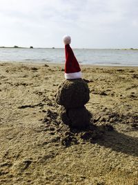 Rear view of woman on beach against sky