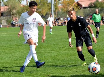 Full length of friends playing soccer on field