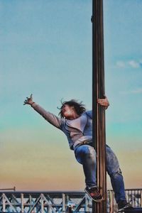 Young woman standing against sky