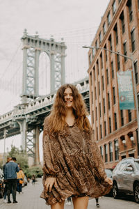 Portrait of woman standing on street in city