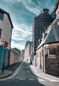 Road amidst buildings against sky in city