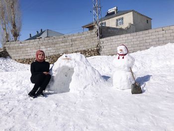 Full length portrait of man with ice cream in snow