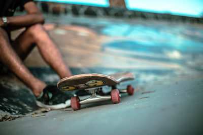 Low section of man with skateboard at park