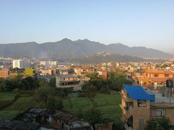 High angle view of houses in town against clear sky