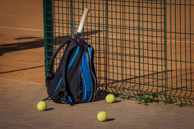 Balls and bag by tennis court