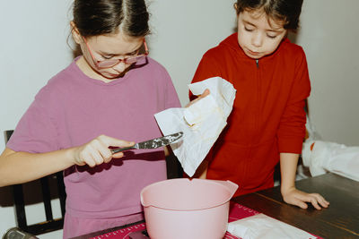 Two beautiful caucasian girls are baking cookies.