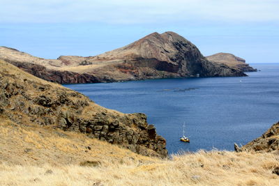 Scenic view of sea with mountain range in background