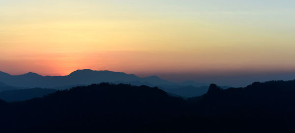 Scenic view of silhouette mountains against sky during sunset