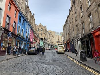 People on street amidst buildings in city