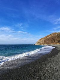 Scenic view of beach against blue sky