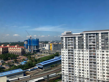 High angle view of buildings against blue sky