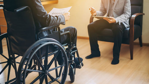 Low section of people sitting on chair