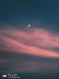 Low angle view of moon in sky at sunset