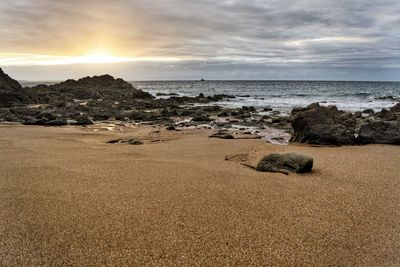 Scenic view of beach against sky during sunset