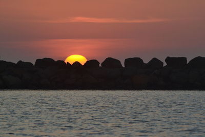 Scenic view of sea against orange sky