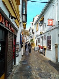 People walking on street amidst buildings in city