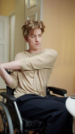 Young man exercising while sitting on wheel chair
