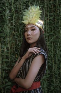 Portrait of woman standing against plants