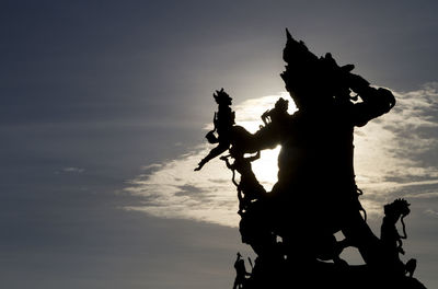 Low angle view of silhouette statue against sky