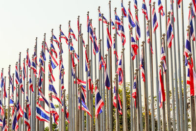 Low angle view of thai flags against clear sky