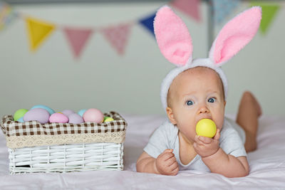 Portrait of cute baby boy with eater eggs