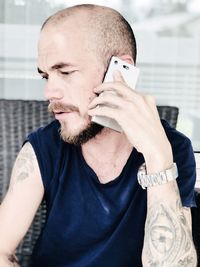 Close-up of man talking on mobile phone at home