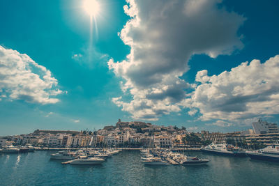 Boats on lake against sky in city