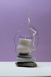 Close-up of ice cream cone on table against wall