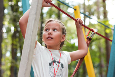 Low angle view of girl doing zip lining at playground