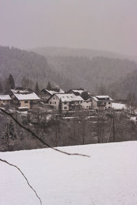 Houses on field by buildings during winter