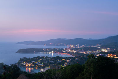 High angle view of illuminated city against sky at sunset