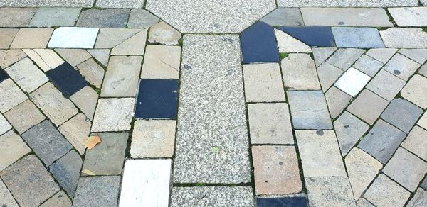 High angle view of arrow symbol on cobblestone street