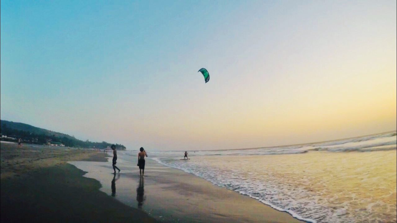 PEOPLE ON BEACH AGAINST CLEAR SKY