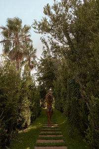 Rear view of woman walking on grass