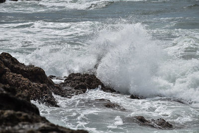 Waves breaking on rocks in sea