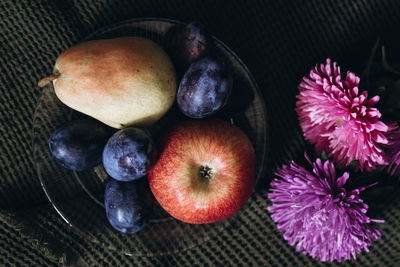 Apples and plums on the table