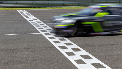 Race car blurred motion crossing the finish line on international circuit speed track, motion blur.