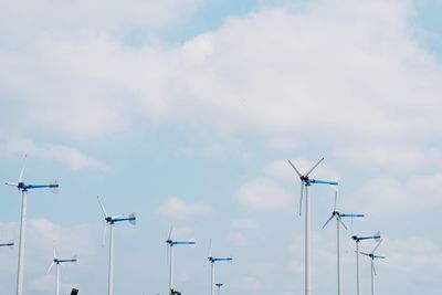 Low angle view of windmills against sky