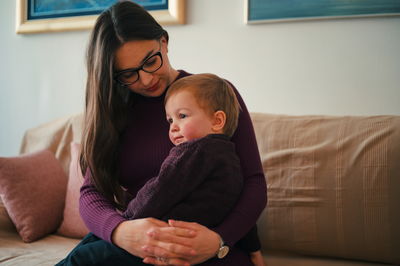 Mother holding her little toddler in a lap